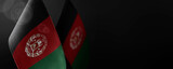 Small national flags of the Afghanistan on a dark background