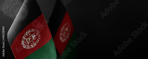 Small national flags of the Afghanistan on a dark background