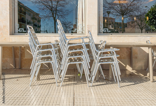 Metal chairs and tables stacked outdoor. Coronavirus crisis