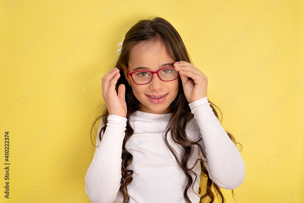 Fototapeta premium Funny child girl in glasses on colored background