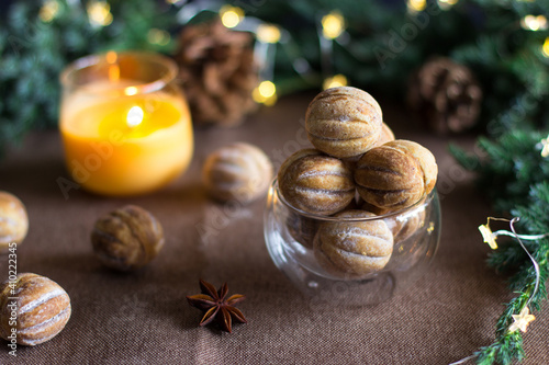 Nuts with condensed milk on a brown background against a background of fir branches