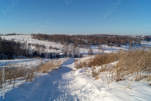 Winter landscape with hilly terrain in Russia on turn blue background a sky