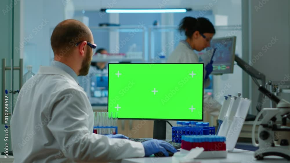 Researcher looking at chroma key display in modern equipped lab ...