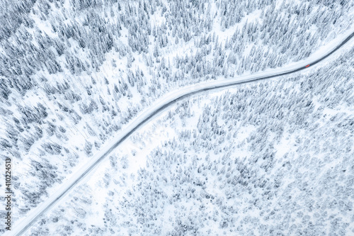 Aerial drone view of road in winter forest with red car © Nikolay N. Antonov