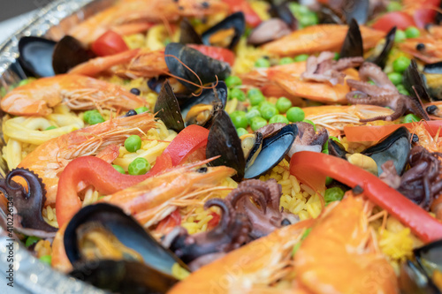 Spanish Rice Paella served on aluminum takeout tray. 