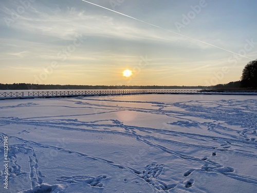 View of the frozen Białe Lake near Włodawa with wooden decks a lot of snow just before sunset golden hour