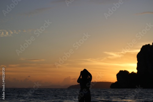 Woman posing at sunset on a beach in a swimsuit 