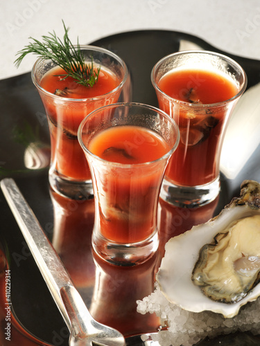 three of bloody mary shots served with oyster 