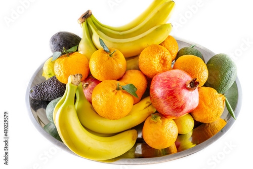 Assorted fruit and vegetable platter of bananas  pomegranate  lemon  tangerine and avocado.