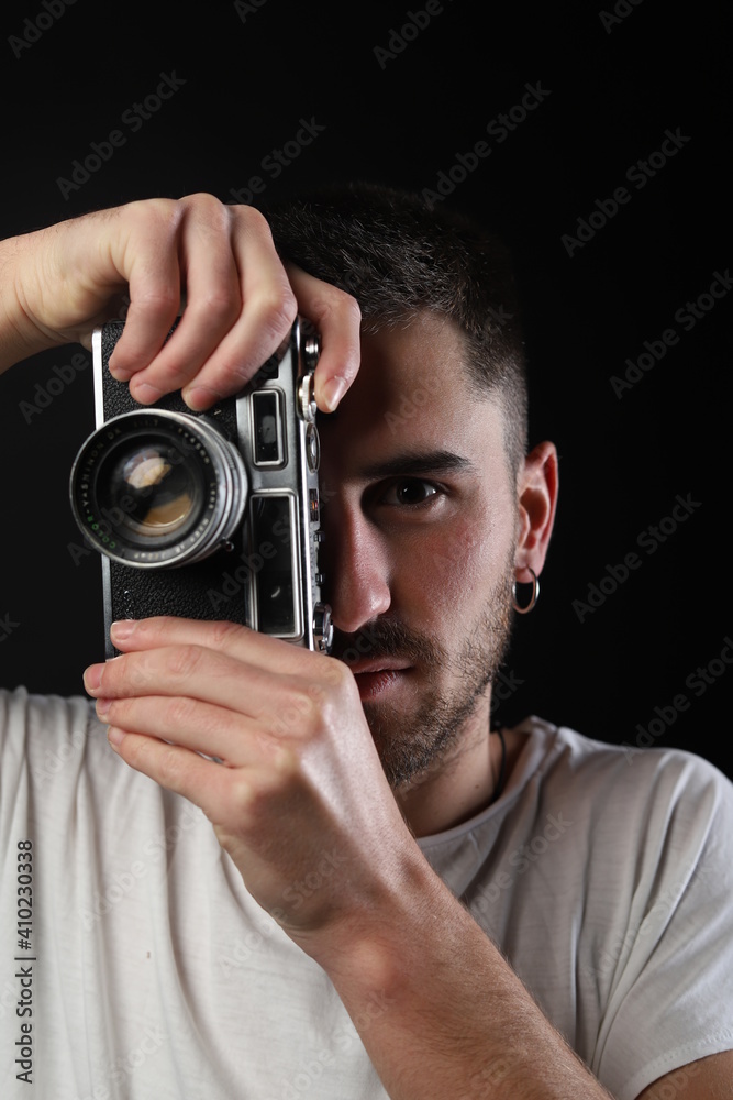 Young man posing with an analog camera Young man posing with an analog camera