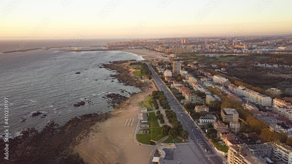 Aerial view of Porto city, Portugal, Europe. Drone flying over houses located at coastline of atlantic ocean. Panoramic cityscape of Porto at sunset. 4k footage in hyper lapse
