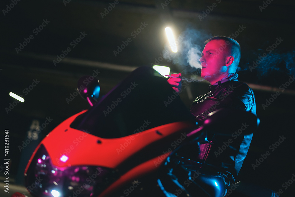 Fototapeta premium A motor biker is smoking a cigarette close up.