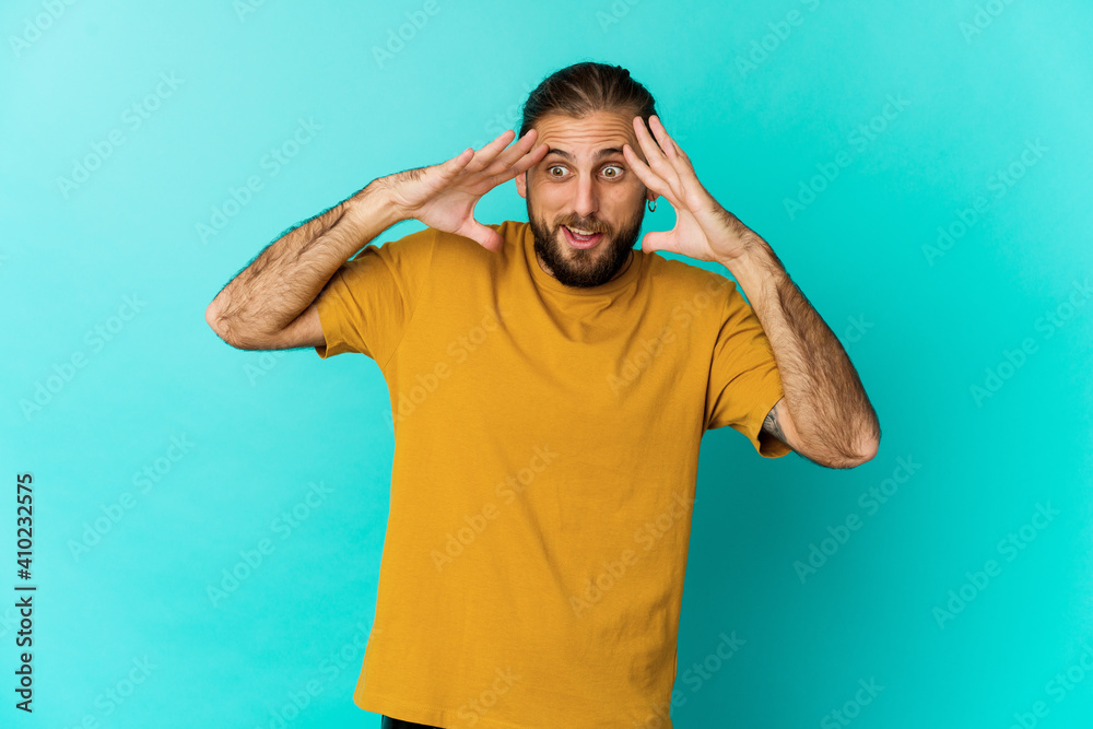 Young man with long hair look receiving a pleasant surprise, excited and raising hands. Young man with long hair look receiving a pleasant surprise, excited and raising hands.