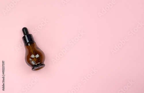 A bottle of natural body oil. Serum in a glass bottle. Cosmetic oil in glass bottle with pipette