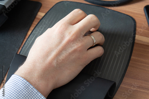 a man's hand on a computer mouse remote work