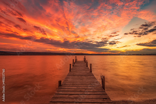 Exciting colorful sunset view from the shore with a wooden pier