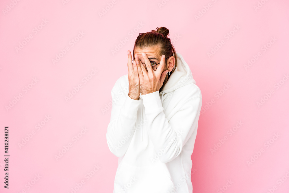 Young man with long hair look blink through fingers frightened and nervous. Young man with long hair look blink through fingers frightened and nervous.