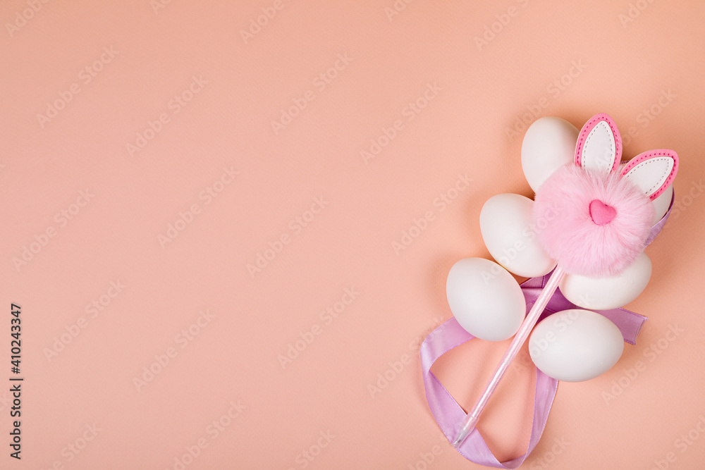 Fototapeta premium Easter. White eggs with an artificial rabbit on a uniform background.