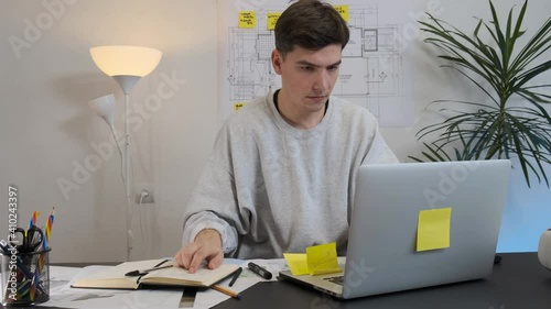 A young architect writes down his ideas in a notebook.