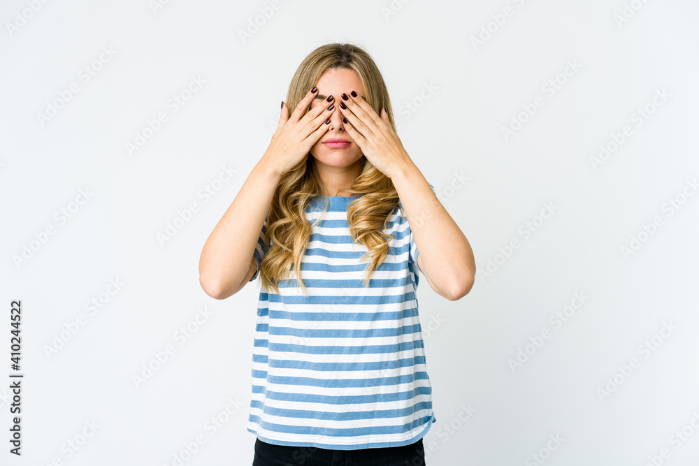Young caucasian blonde woman afraid covering eyes with hands. Young caucasian blonde woman afraid covering eyes with hands.