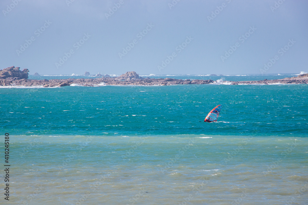 A windsurfer enjoying the beautiful scenery of the coast of Ploudalmezeau, Finistere, Bretagne, France