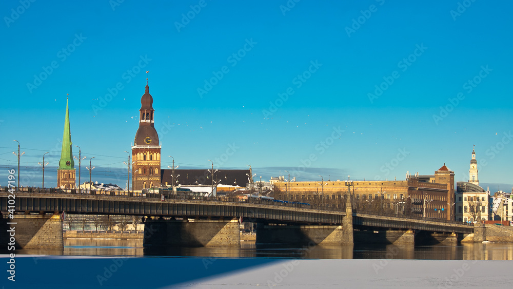 riga. in the photo, a panorama of the city and a stone bridge against the blue sky