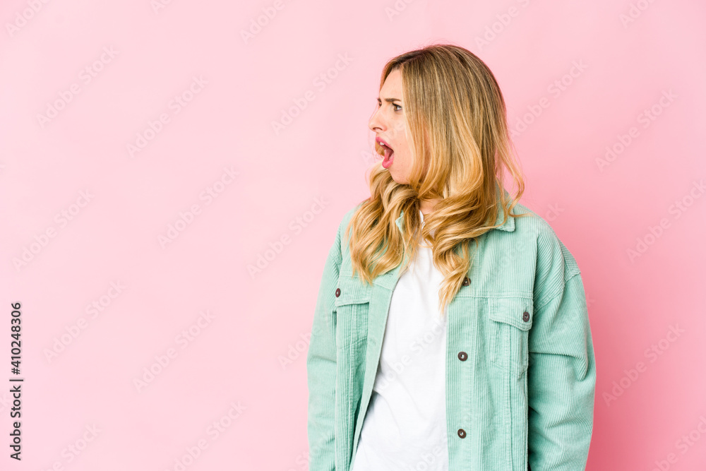 Young caucasian blonde woman shouting very angry, rage concept, frustrated.