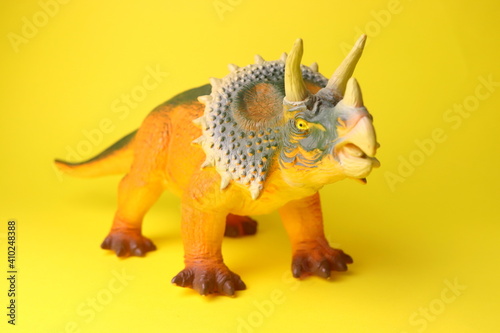 Fototapeta Naklejka Na Ścianę i Meble -  toy dinosaur close-up on a yellow background selective focus, childrens toys.