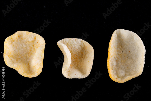 Potatoes snack with pepper on isolated black background. Closeup