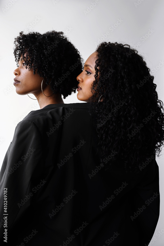 Two beautiful dark skin women wearing same jacket Two beautiful dark skin women wearing same jacket