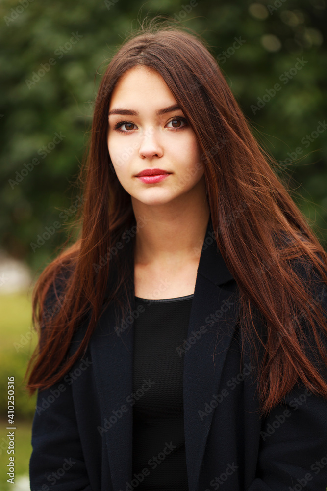 Fototapeta premium Young beautiful brunette girl in the autumn park