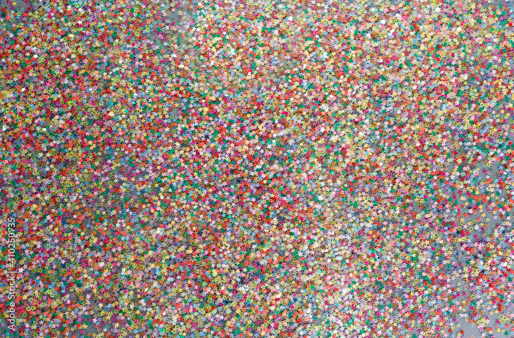 multicolored confetti on a gray background top view.