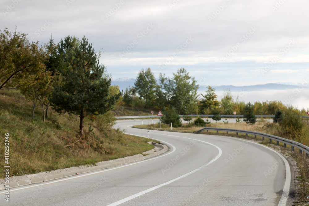 Naklejka premium a traffic warning sign before a sharp bend in the road