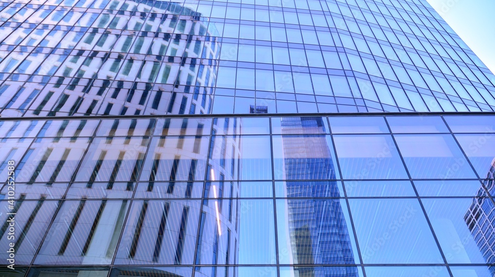 Glass facade of the buildings with a blue sky. Skyscrapers in the business city center.. Background of modern glass buildings. Glass facade of the buildings with a blue sky. Skyscrapers in the business city center.. Background of modern glass buildings.
