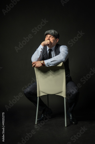 in a cap on a chair Young male three piece suit fashion, attractive casual clothing. Men city, success smile background black bodybuilder