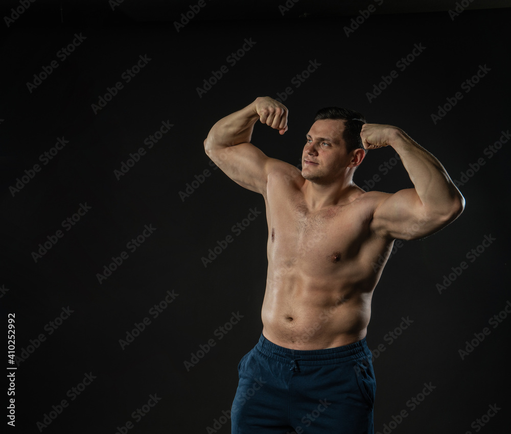 Man's biceps shows bare torso Young male business model, attractive guy bodybuilder. Men boy success single background black bodybuilder