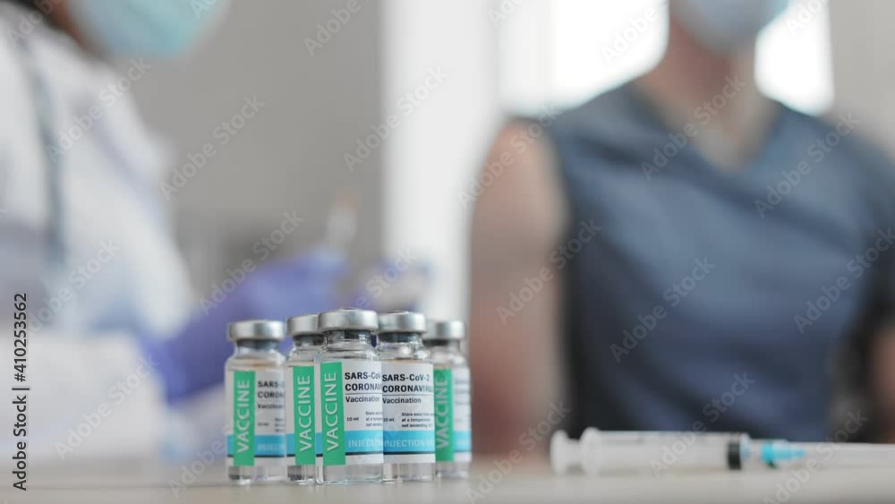 Global pandemic finishes. Health concept. Doctor vaccinating male. Adult patient getting vaccine injection in hand. Immunity stimulation to minimise risk of coronavirus infection. Focus on ampoules.
