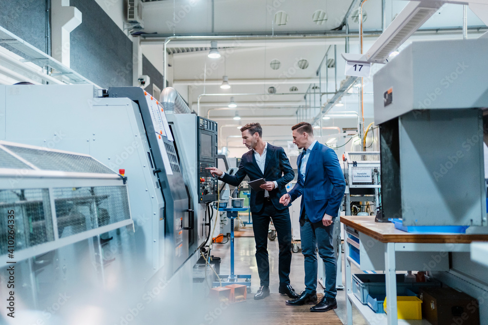 © Daniel Ingold/Westend61 - Male professionals operating manufacturing equipment in industry