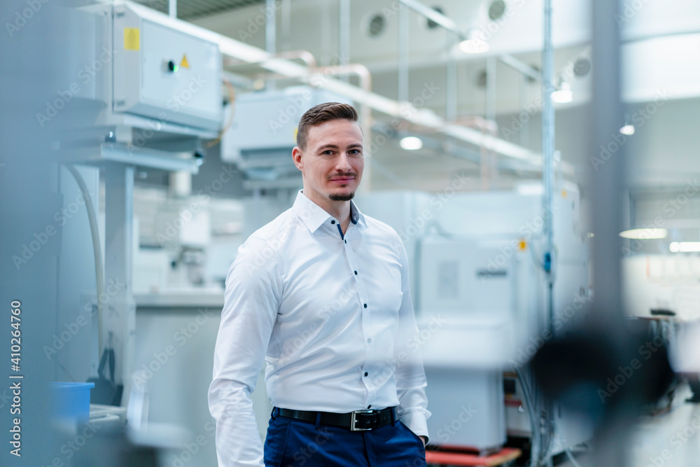 Male professional with hands in pockets standing in factory Male professional with hands in pockets standing in factory
