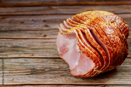 Delicious honey smoked pork ham on wooden background.