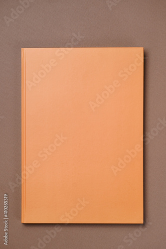 Orange Leather notebook on paper brown background, notepad mock up, top view shot
