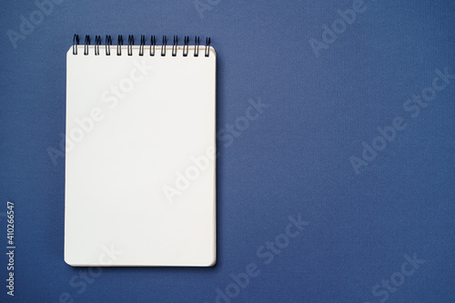 School notebook on a paper blue background, spiral notepad and craft cardboard pen