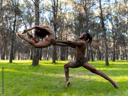 Two professional dancers performing in underwear in middle of forest