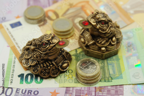 Foto Two Chinese Feng shui frogs sitting on euro banknotes