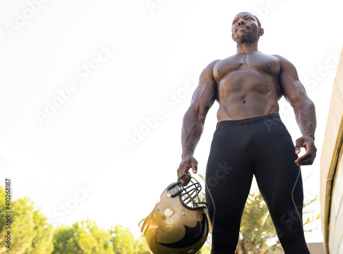 Active sportsman with helmet standing in park against clear sky photo