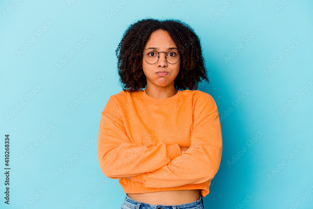 Obraz premium Young african american mixed race woman isolated blows cheeks, has tired expression. Facial expression concept.