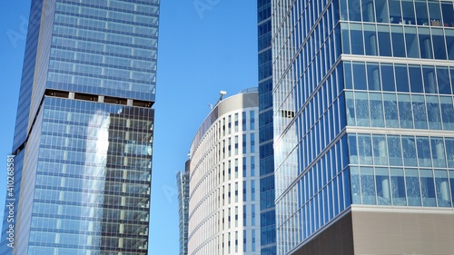 Glass facade of the buildings with a blue sky. Skyscrapers in the business city center.. Background of modern glass buildings. 