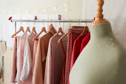 Dressmaker's model against clothes rack at design studio photo
