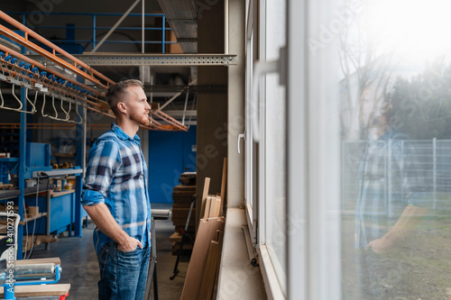 Wallpaper Mural Portrait of carpenter looking through window in production hall Torontodigital.ca