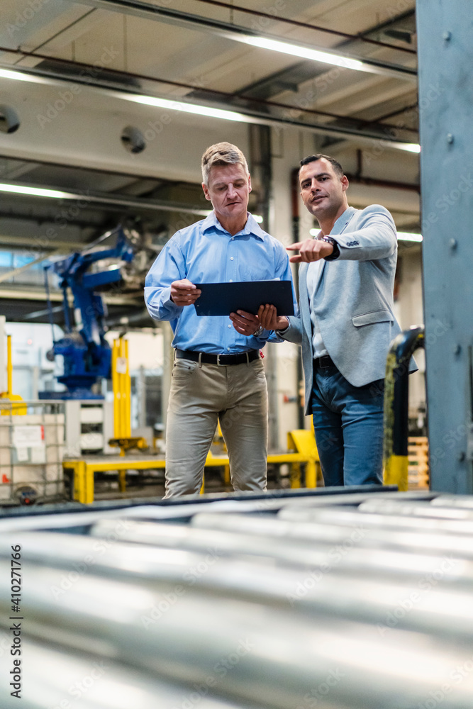 Mature manager looking at document while discussing with supervisor in industry Mature manager looking at document while discussing with supervisor in industry